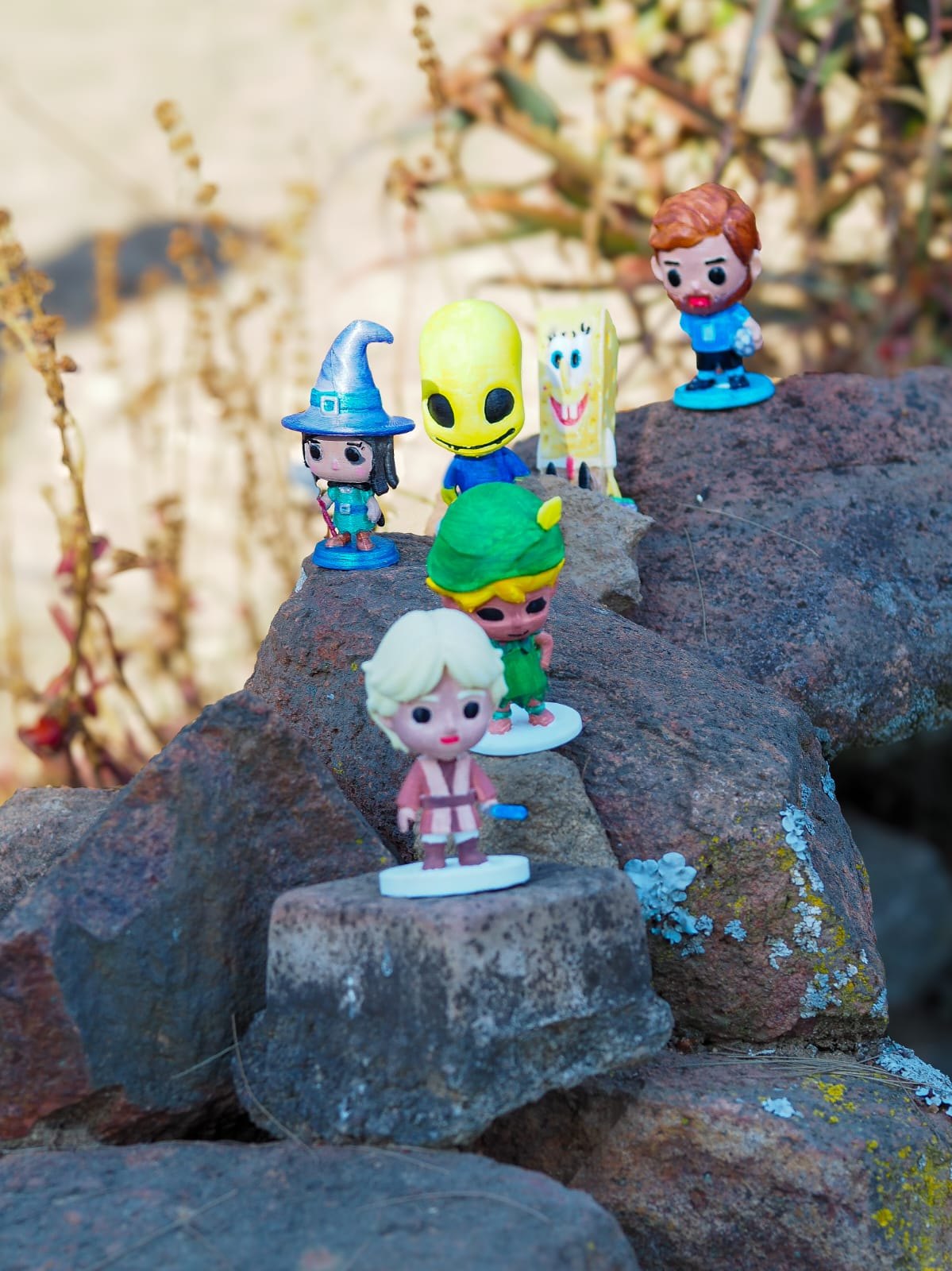 Five hand-painted ColourPops standing on garden rocks